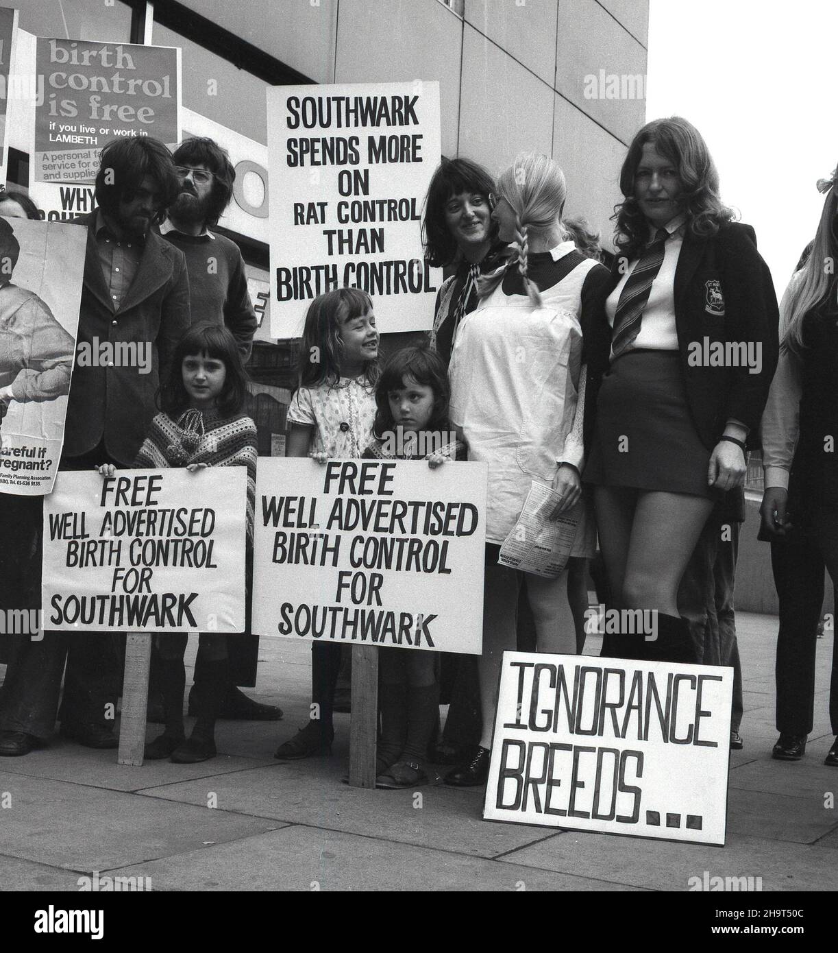 1970s, eine historische Gruppe von Menschen, hauptsächlich Frauen, mit Spruchbändern und Plakaten, die vor einem Einkaufszentrum einen Protest gegen das Versagen des Southwark Council, kostenlose Geburts- und Verhütungsmittel anzubieten, abhielten. Auf einem Poster steht: „Southwark gibt mehr für Rattenkontrolle aus als für Geburtenkontrolle“. Bis Ende 1970s blieb die Fähigkeit unverheirateter junger Frauen, Empfängnisverhütung zu erhalten und unerwünschte Vorgebausbildungen zu verhindern, begrenzt. Stockfoto