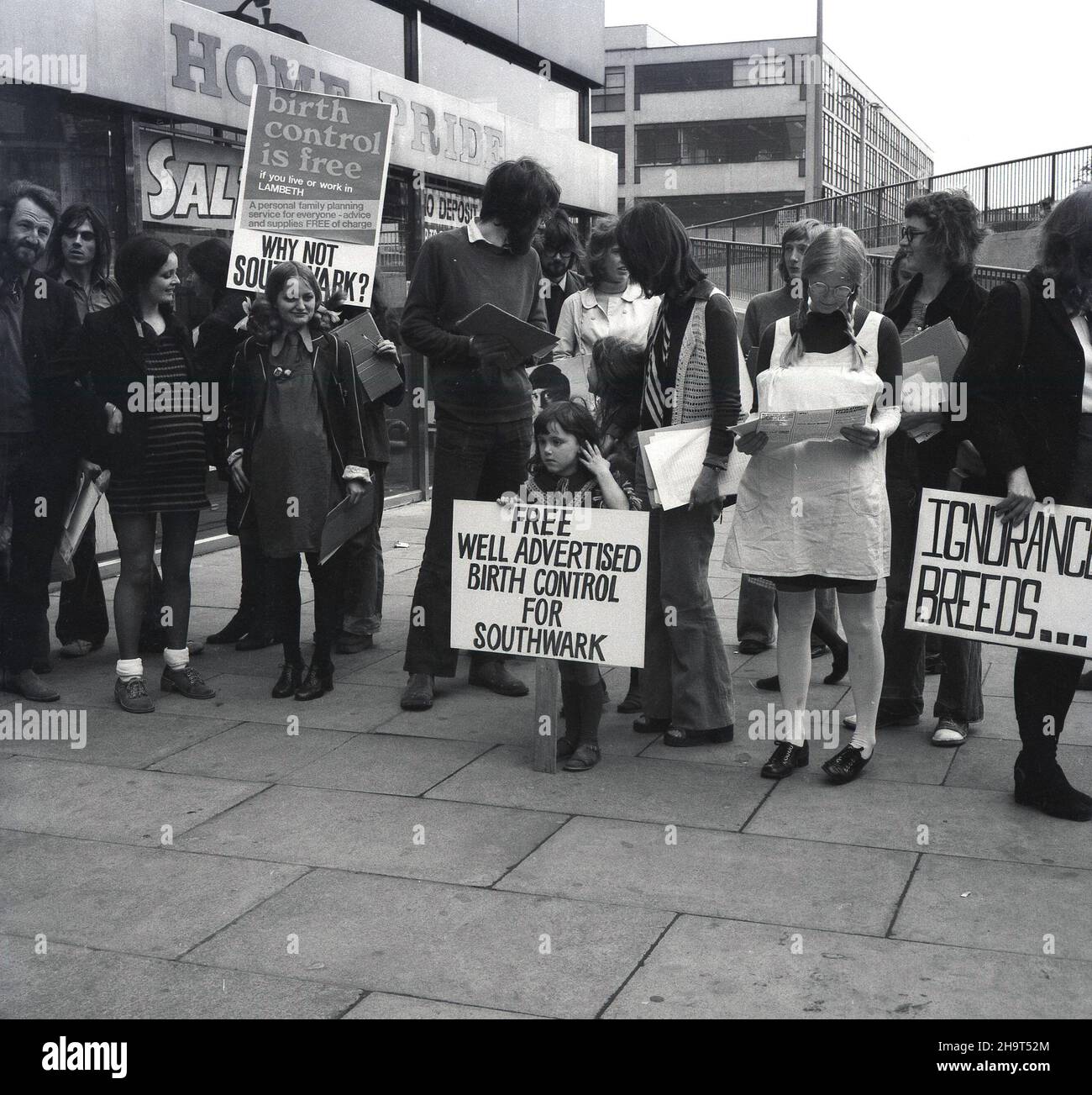 1970s, eine historische Gruppe von Menschen, hauptsächlich Frauen, mit Spruchbändern und Plakaten, die vor einem Einkaufszentrum einen Protest gegen das Versagen des Southwark Council, kostenlose Geburts- und Verhütungsmittel anzubieten, abhielten. Auf einem Poster steht: „Southwark gibt mehr für Rattenkontrolle aus als für Geburtenkontrolle“. Bis Ende 1970s blieb die Fähigkeit unverheirateter junger Frauen, Empfängnisverhütung zu erhalten und unerwünschte Vorgebausbildungen zu verhindern, begrenzt. Stockfoto