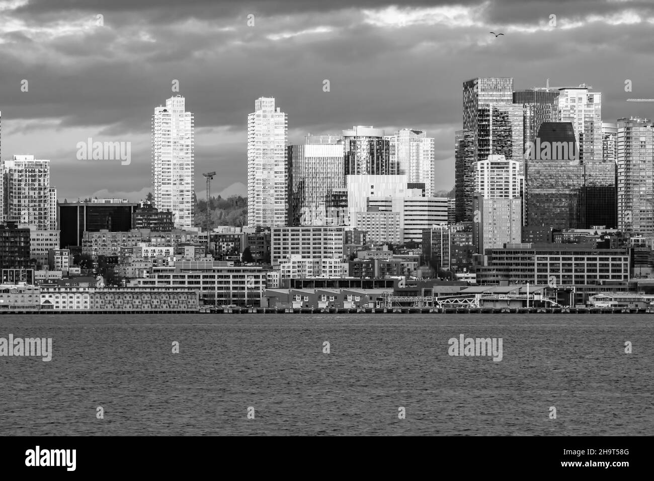 Die untergehende Sonne lässt einen Teil der Stadt Seattle über der Elliott Bay erstrahlen. Stockfoto
