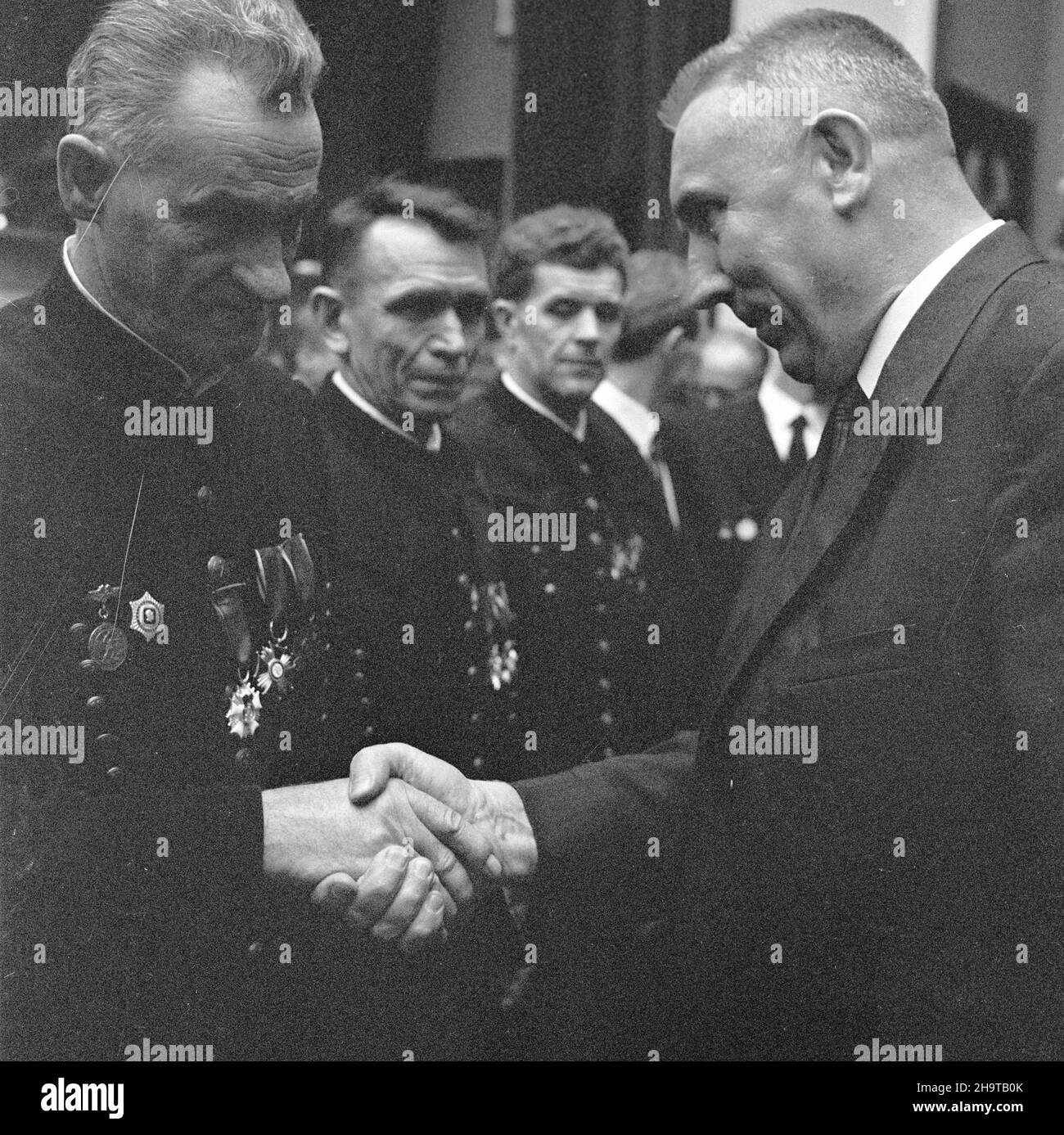Sosnowiec, 1969-11-29. Z okazji dnia Górnika w Domu Kultury kopalni Milowice odby³a siê akademia pracowników kopalñ i zak³adów górniczych D¹browskiego Zjednoczenia Przemys³u Wêglowego. Uczestniczyli w niej: cz³onek Biura Politycznego KC, i sekretarz Komitetu Wojewódzkiego PZPR w Katowicach – Edward Gierek, Minister górnictwa i energetyki – Jan Mitrêga i przewodnicz¹cy Zarz¹du G³ównego Zwi¹zku Zawodowego Górników – Micha³ Specja³. Podczas uroczystoœci E. Gierek udekorowa³ odznaczeniami pañstwowymi zas³u¿onych górników. Nz. E. Gierek (P) gratuluje wyró¿nionym pracownikom górnictwa. uu PAP/Kazi Stockfoto