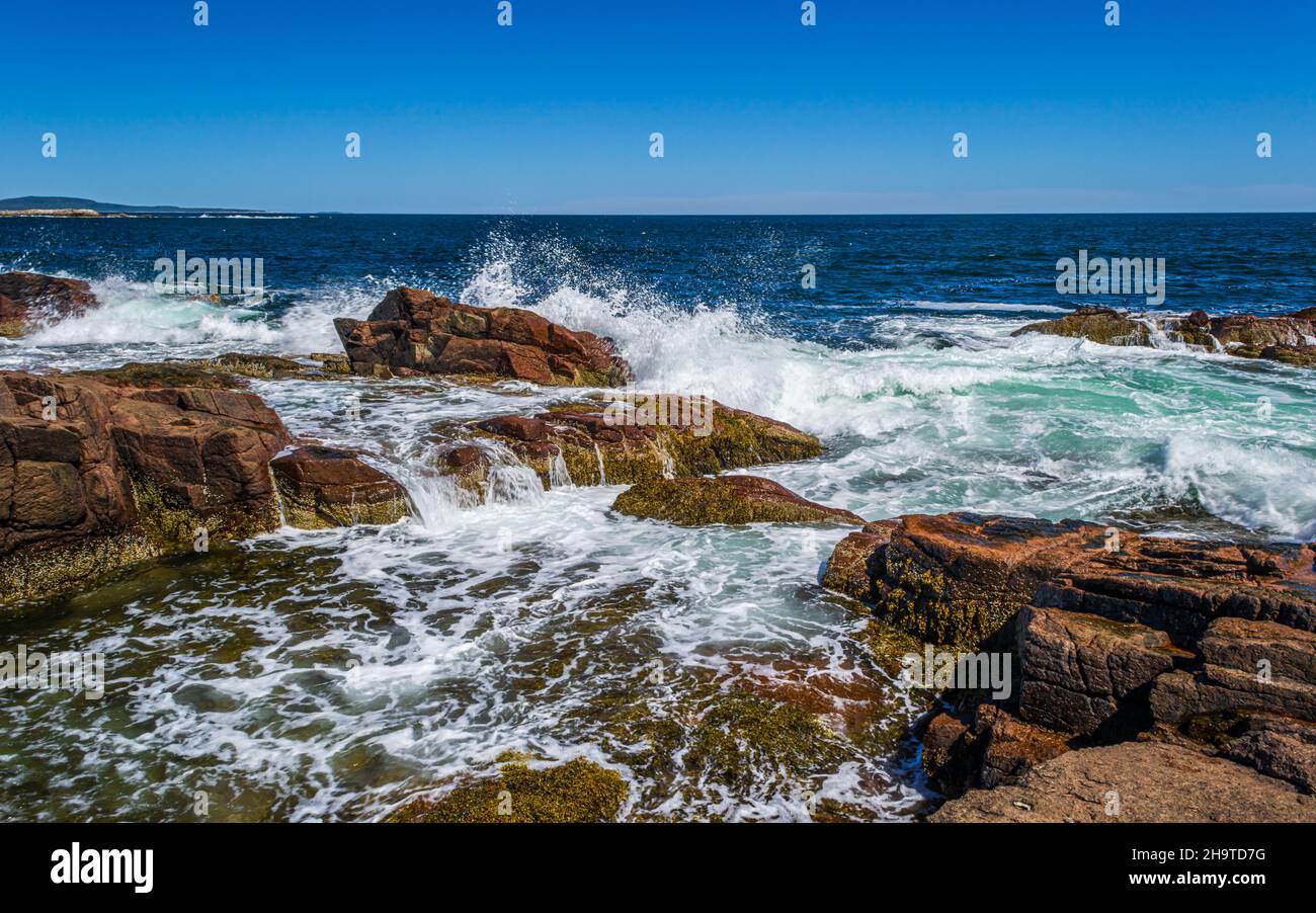 Die Wellen des Atlantischen Ozeans schlagen gegen die großen Felsformationen an der Küste von Mount Desert Island, Maine, USA. Stockfoto