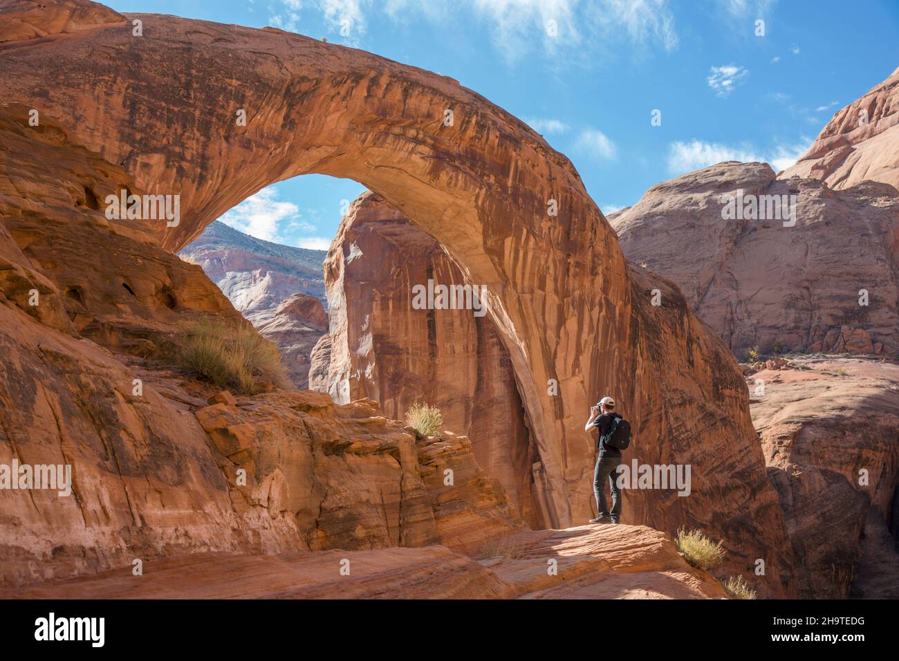 Glen Canyon National Recreation Area, Utah, USA. Der Fotograf fotografiert den riesigen Sandsteinbogen des Rainbow Bridge National Monument im Hintergrund. Stockfoto