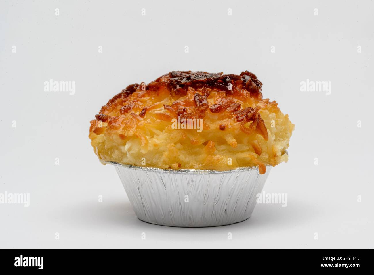Kokosnuss-Süßigkeiten. Traditionelles brasilianisches Dessert, auch bekannt als Queijadinha, auf weißem Hintergrund. Stockfoto