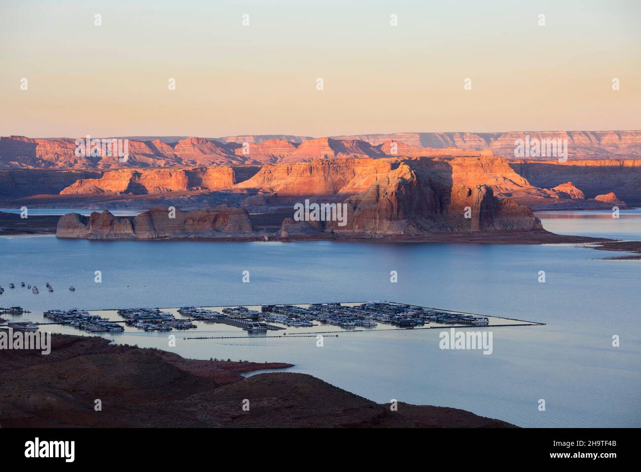 Glen Canyon National Recreation Area, Page, Arizona, USA. Blick über den Jachthafen von Wahweap auf die hohen schroffen Klippen von Castle Rock und Romana Mesa, Sonnenuntergang. Stockfoto