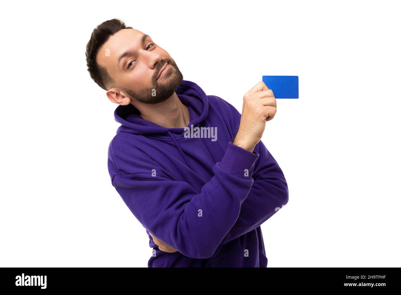 Ein Mann in einem violetten Hoodie demonstriert eine Rabattkarte Stockfoto