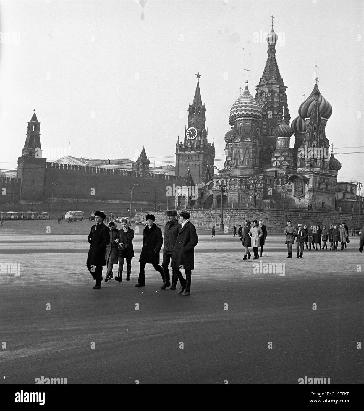 Rosja, Moskwa, 1969-12-08. Stolica i najwiêksze miasto ZSRR. Moskwa jest siedzib¹ najwy¿szych w³adz pañstwowych i partyjnych, a tak¿e najwiêkszym oœrodkiem gospodarczym i kulturalnym Zwi¹zku Radzieckiego. Agglomeracja miasta, po³o¿onego nad rzek¹ Moskw¹ w Centrum Równiny Rosyjskiej, liczy oko³o 7,1 mln mieszkañców (w roku 1968). Moskwa jest tak¿e najwiêkszym oœrodkiem naukowym w ZSRR. NZ. grupa turystów na Placu Czerwonym na tle cerkwi Wasyla B³ogos³awionego i Kremla. mta PAP/Andrzej Piotrowski Russland, Moskau, 8. Dezember 1969. Die Hauptstadt und die größte Stadt der Union der sowjetischen Sozialistischen Stockfoto