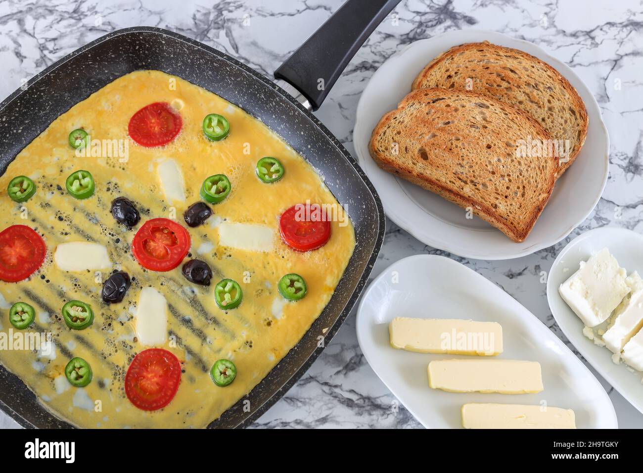 Traditionelles köstliches Omelett mit Gemüse in der Pfanne, Kopierraum, Draufsicht, Lebensmittelkonzept. Stockfoto