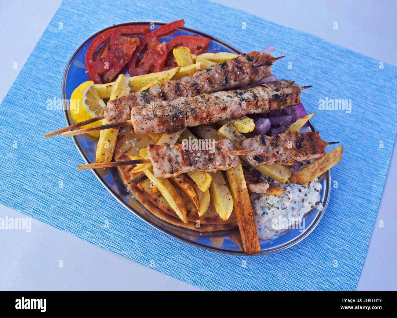 Souvlaki mit Pommes Frites und Tsatsiki in einem Restaurant, Griechenland, Ionische Inseln, Kefalonia, Fiskardo Stockfoto