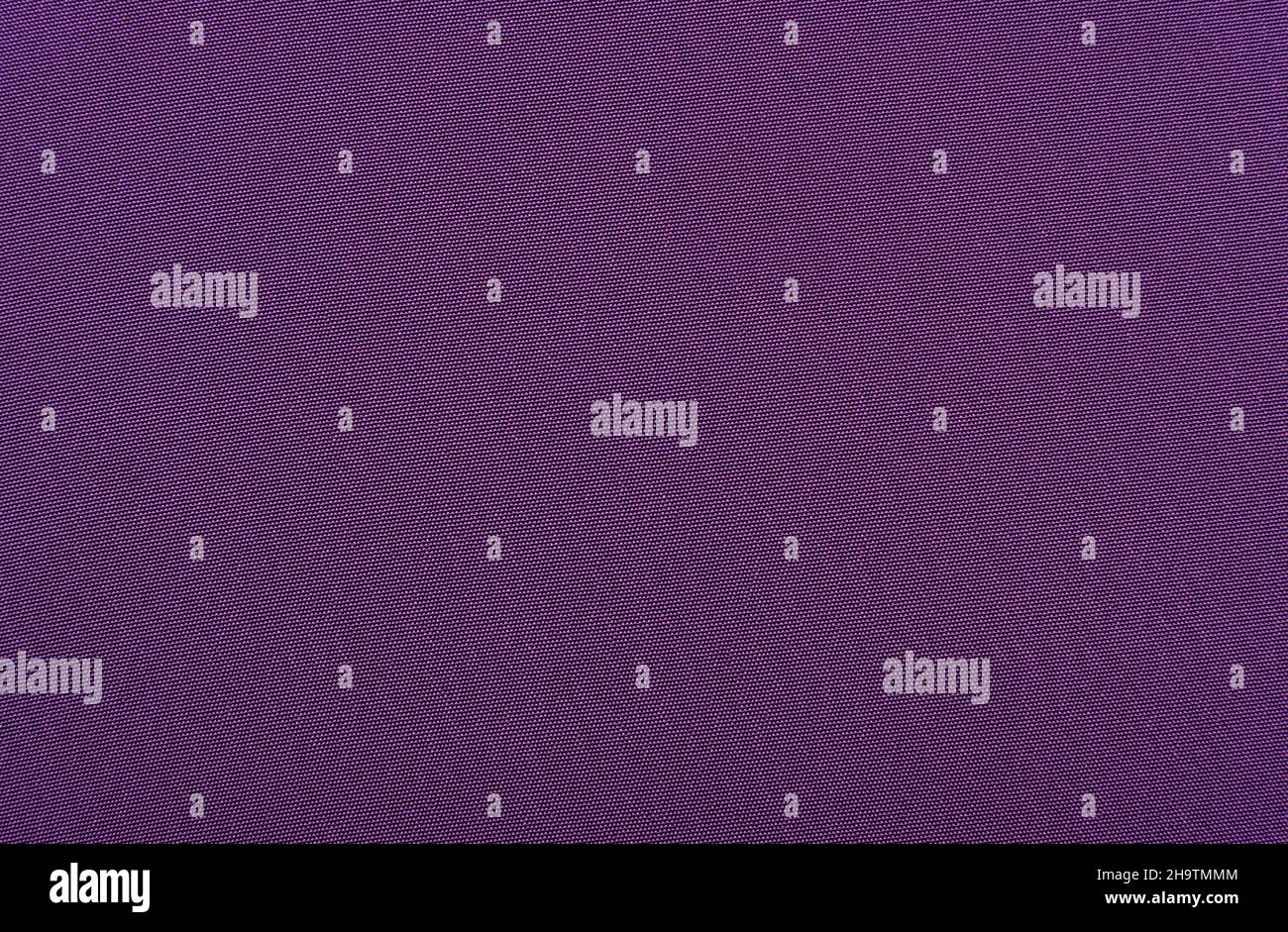 Der Hintergrund ist aus violettem Material. Stoff zum Nähen von Kleidung im dunklen Farbton. Textur Stockfoto