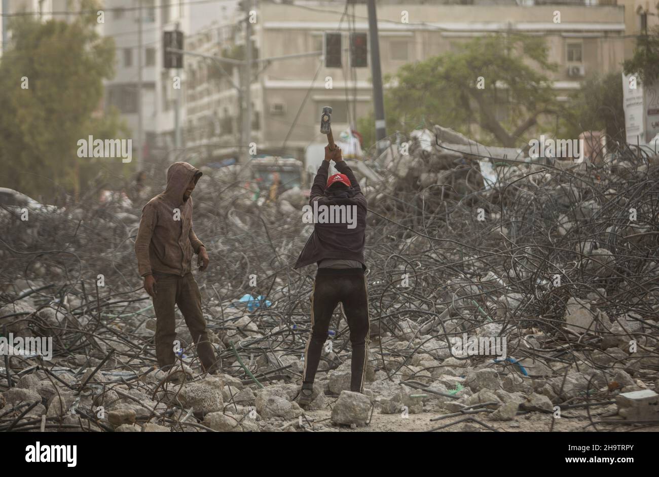 Gaza, Palästina. 08th Dez 2021. Palästinensische Arbeiter entfernen die Trümmer des Al-Jawhara Turms im Viertel Al-Rimal in Gaza-Stadt, der im Mai 2021 von israelischen Luftangriffen angegriffen wurde. Kredit: SOPA Images Limited/Alamy Live Nachrichten Stockfoto
