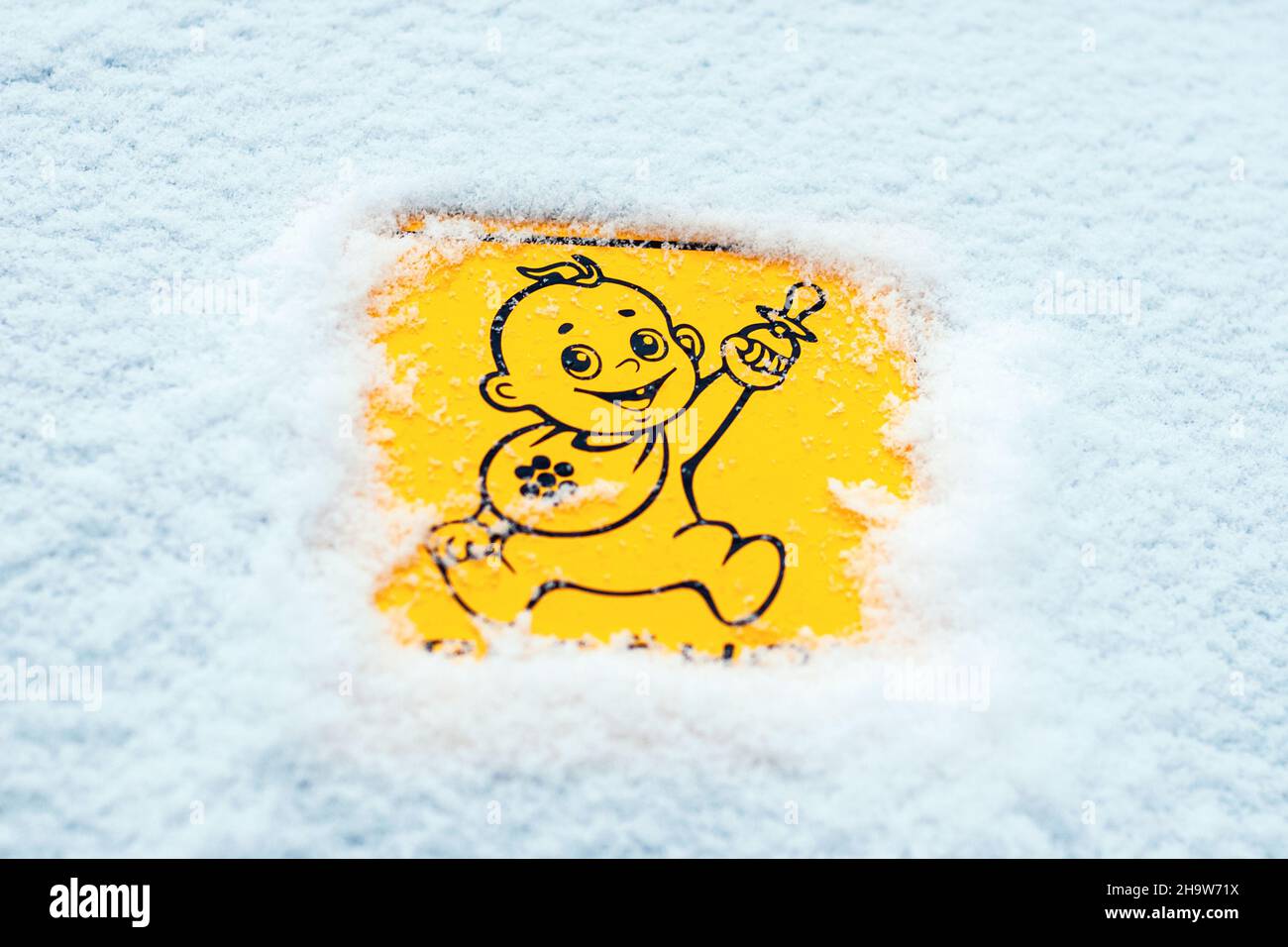 Baby an Bord Aufkleber auf Auto mit Schnee bedeckt, sicheres Fahren im Winter, Reisen mit Kindern Stockfoto
