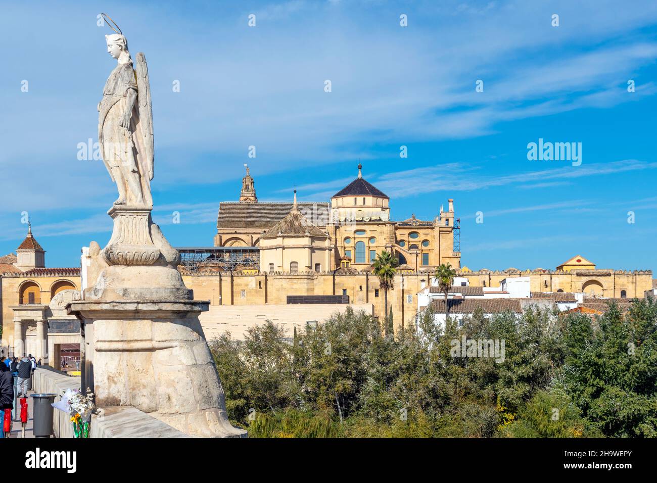 Die Statue des Erzengels Raphael auf der alten römischen Brücke mit dem Schloss und der Stadt Cordoba Spanien im Blick. Stockfoto