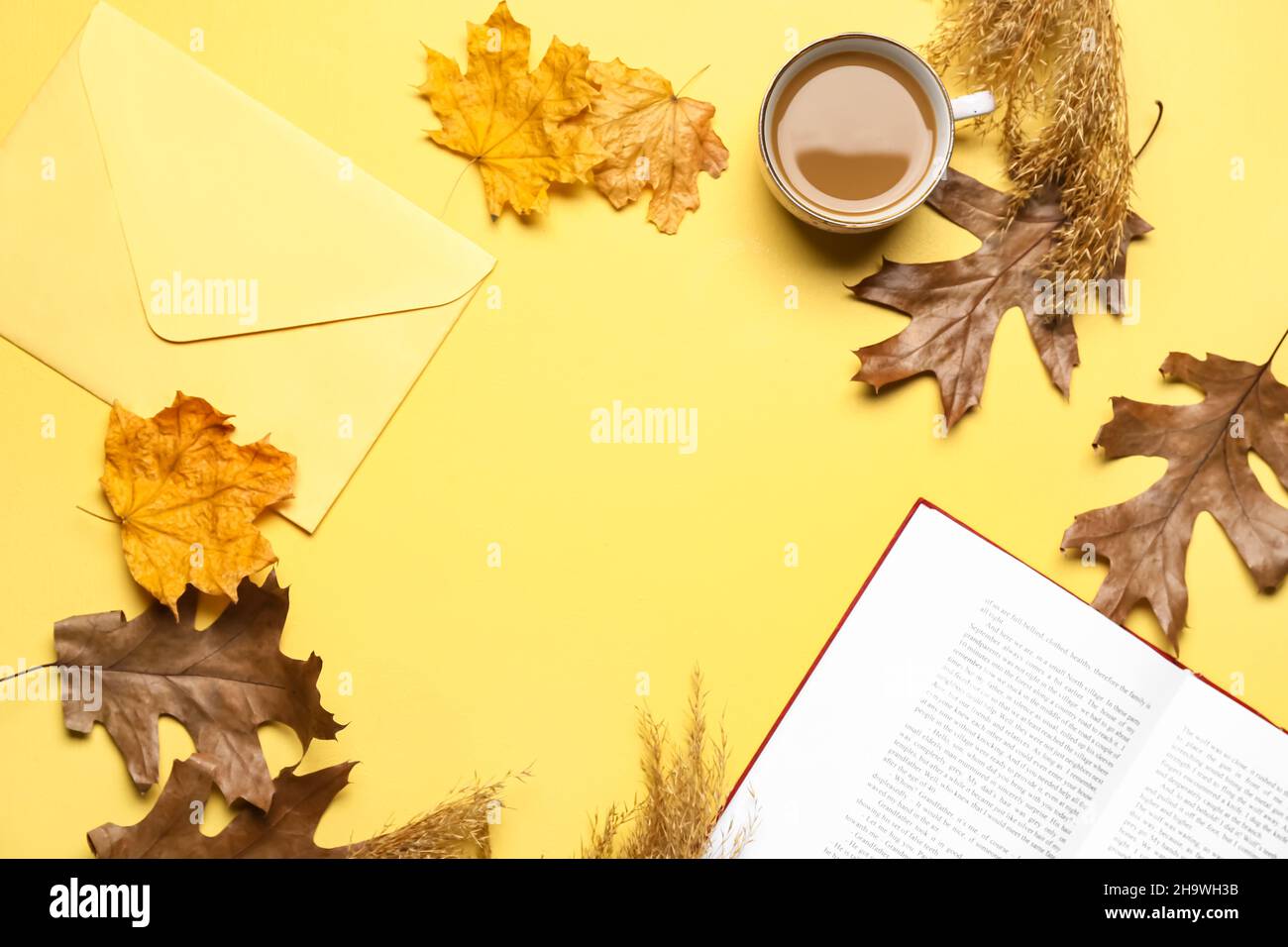 Tasse leckeren Kaffee, Buch, Umschlag und Herbstblätter auf gelbem Hintergrund Stockfoto