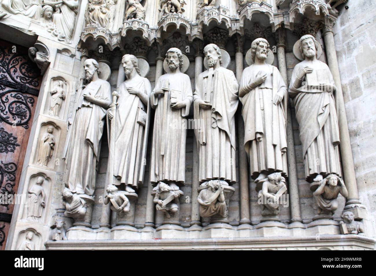 Historische Statuen der Heiligen Paul, James, Thomas, Philip, Jude und Matthew flankieren den Eingang an der façade der Kathedrale Notre Dame in Paris, Frankreich. Stockfoto