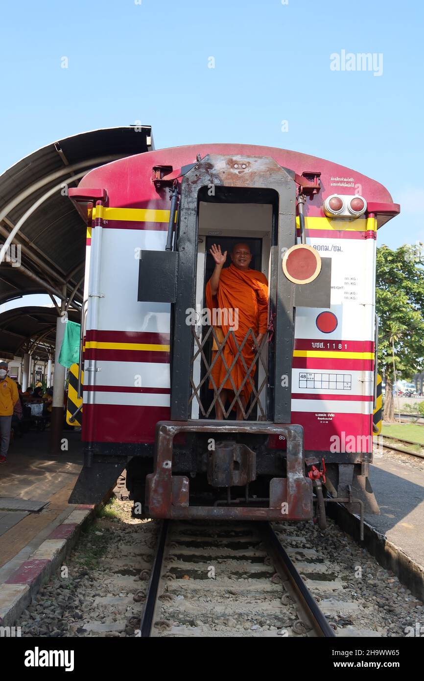 Lächelnder buddhistischer Mönch winkt hinter dem Zug, Hua Lamphong Bahnhof, Bangkok, Thailand Stockfoto