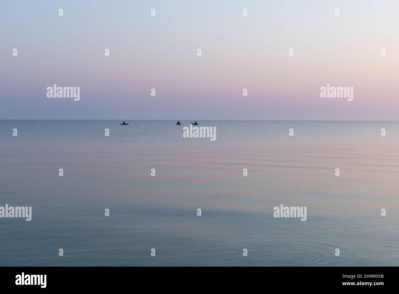 Meer in der Morgendämmerung mit drei Fischerbooten, ruhig, Asowschen Meer, Russland. Stockfoto