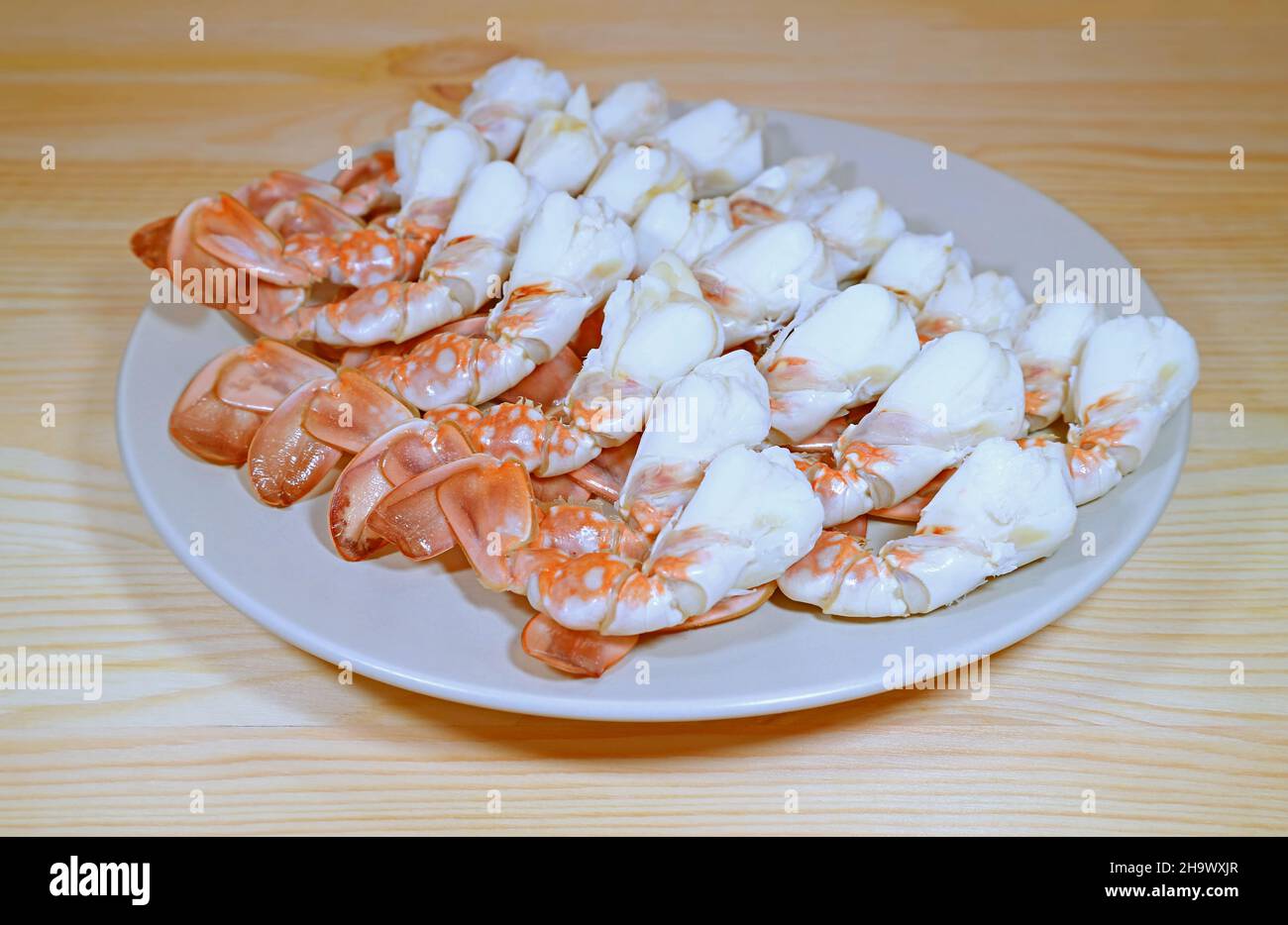 Teller mit köstlichen gedämpften Blütenkrabbenbeinen auf einem Holztisch Stockfoto