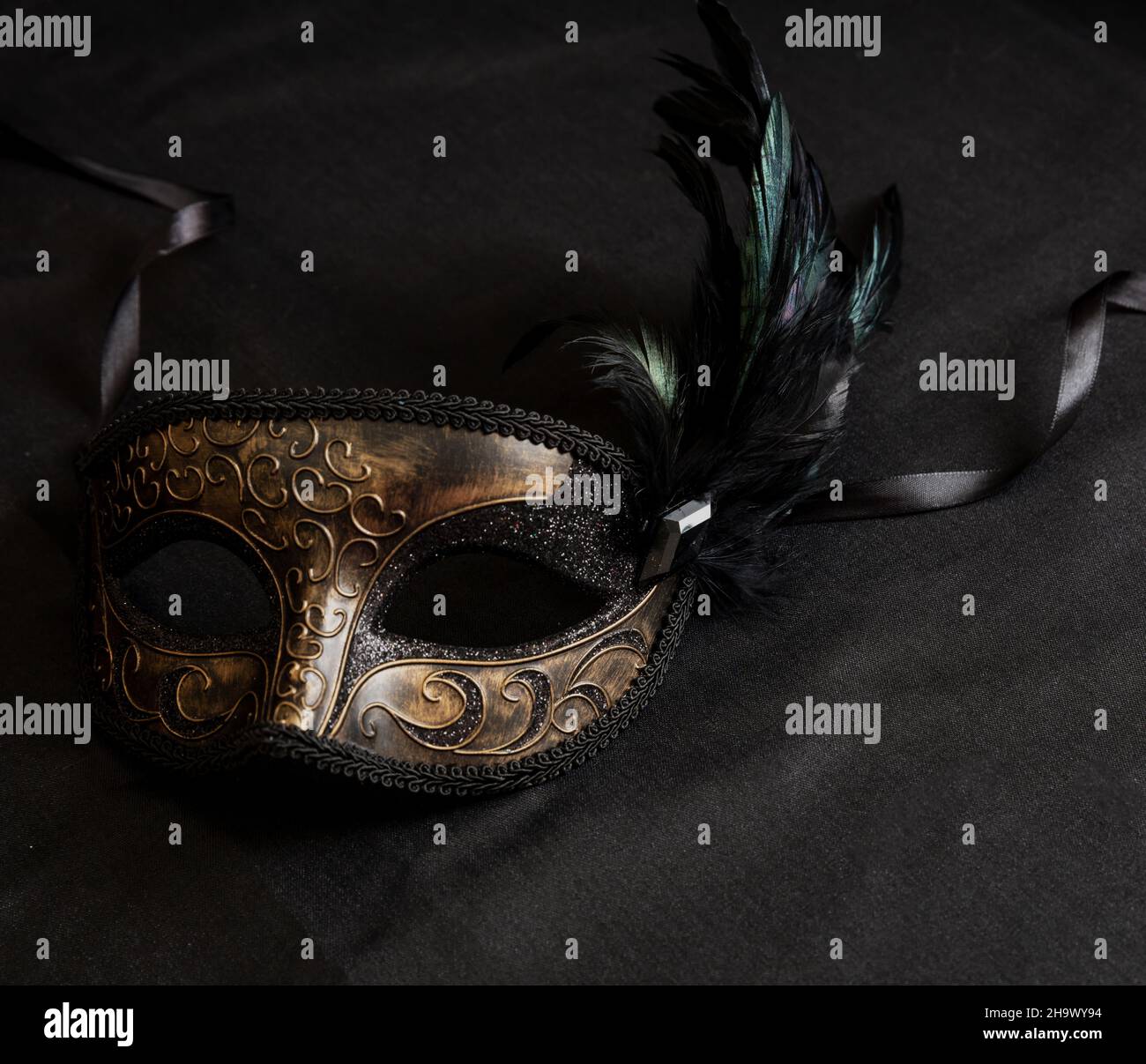 Karnevalsparty. Venezianische Maske mit schwarzen Federn auf dunkelgrauem Hintergrund, Kopierraum, Schablone. Traditionelle Festival weibliche Verkleidung, Maskerade Stockfoto