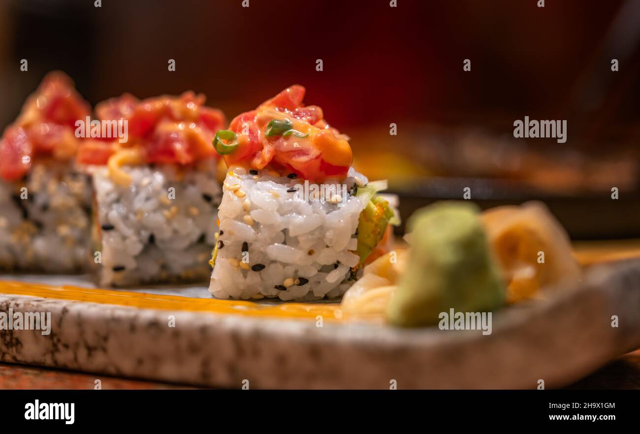 Makro-Sushi-Rolle von würzigem rohem Thunfisch auf einem schönen Steinteller, gesundes japanisches Essen, Sushi-Rolle mit weicher Fokussierung in dunkler Stimmung. Stockfoto
