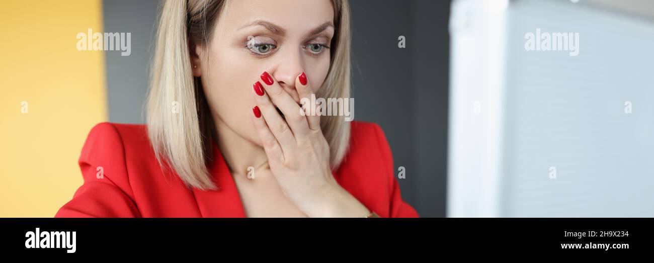 Überraschte Frau, die in einen offenen Koffer mit Geld schaute und ihren Mund mit der Hand bedeckte Stockfoto
