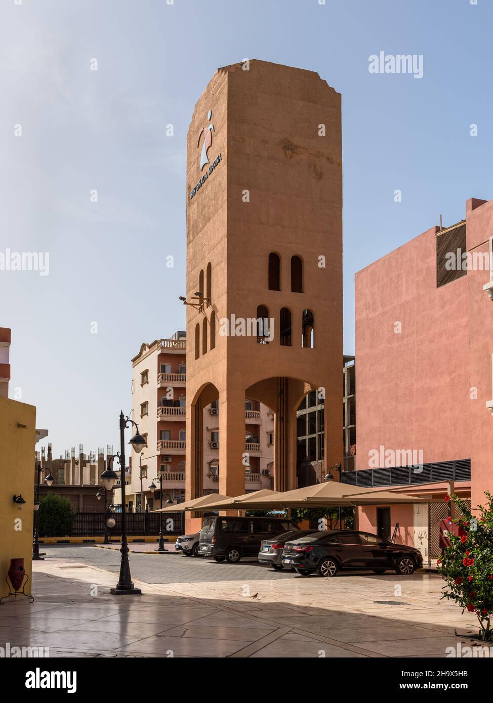 Hurghada, Ägypten - 31. Mai 2021: Straßenansicht des New Marina Boulevards in Hurghada mit einem hohen Turm und geparkten Autos, beliebte Strandresort Stadt entlang Red Stockfoto