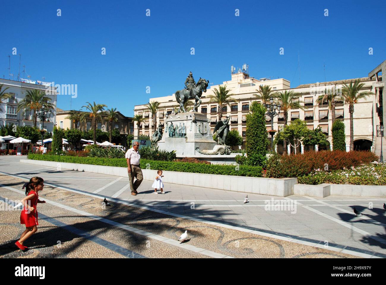 Denkmal auf der Plaza del Arenal und Kinder mit ihrem Großvater im Vordergrund, Jerez de la Frontera, Provinz Cadaz, Andalusien, Spanien. Stockfoto