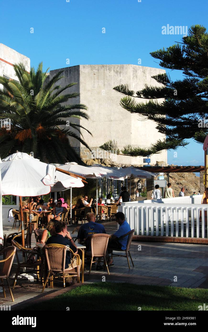 Turm des Schlosses Guzman el Xeno mit einem Straßencafé im Vordergrund, Tarifa, Costa de la Luz, Provinz Cadiz, Andalusien, Spanien, Westeuropa. Stockfoto