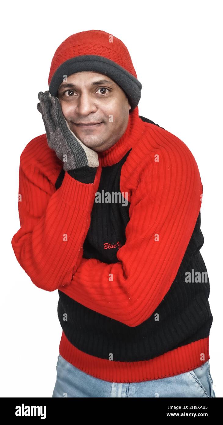 Junger Inder mit Wollpullover, Handschuhen und Mütze, Wintersaison, rotem  und schwarzem Pullover und Mütze, graue Handhandschuhe, isoliert auf weißem  Rücken Stockfotografie - Alamy