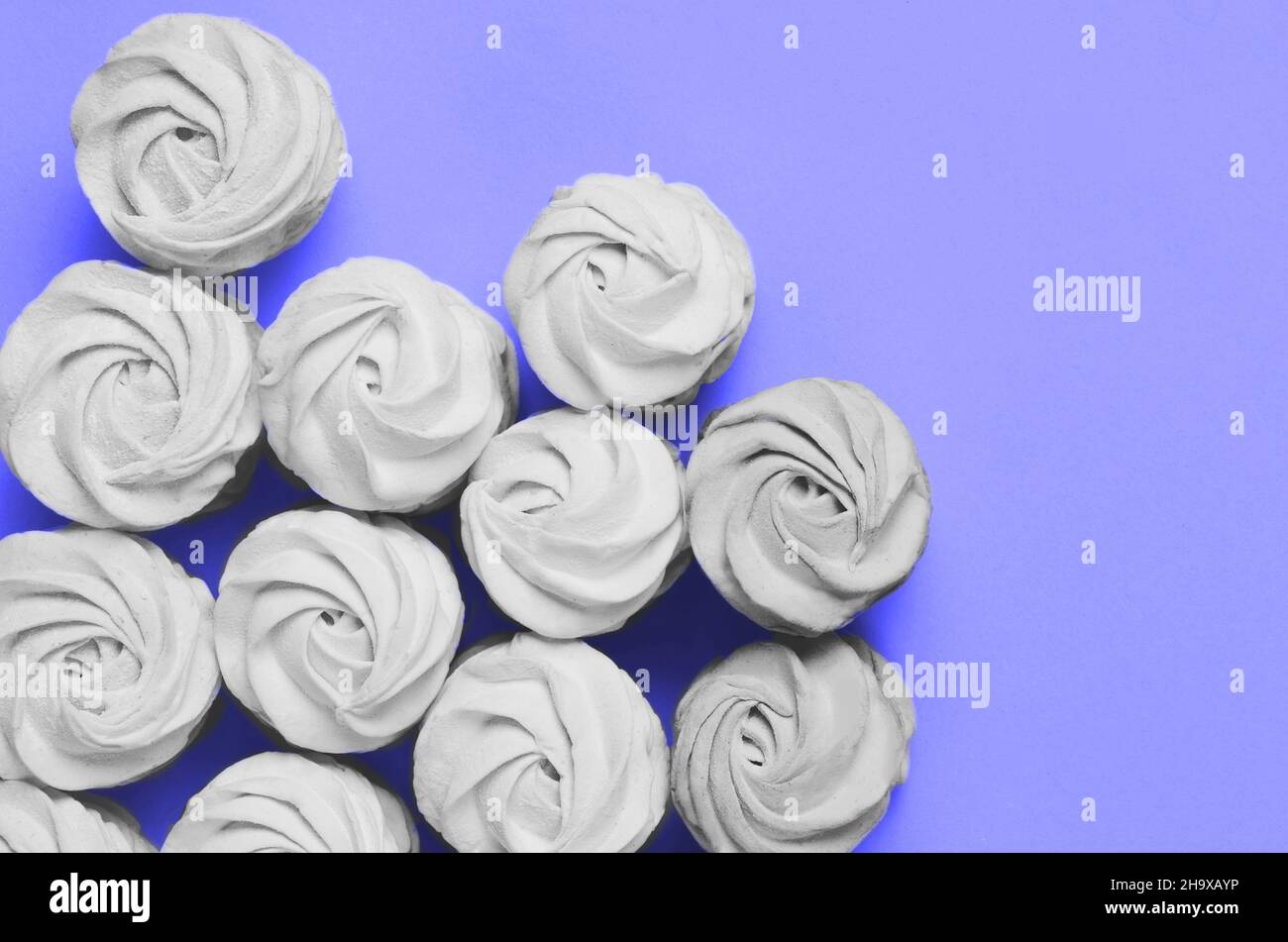 Farbe des Jahres 2022. Sehr peri. Marschlallows auf violettem Hintergrund. Hausgemachte Marschlallow. Flach liegend, Platz zum Kopieren Stockfoto