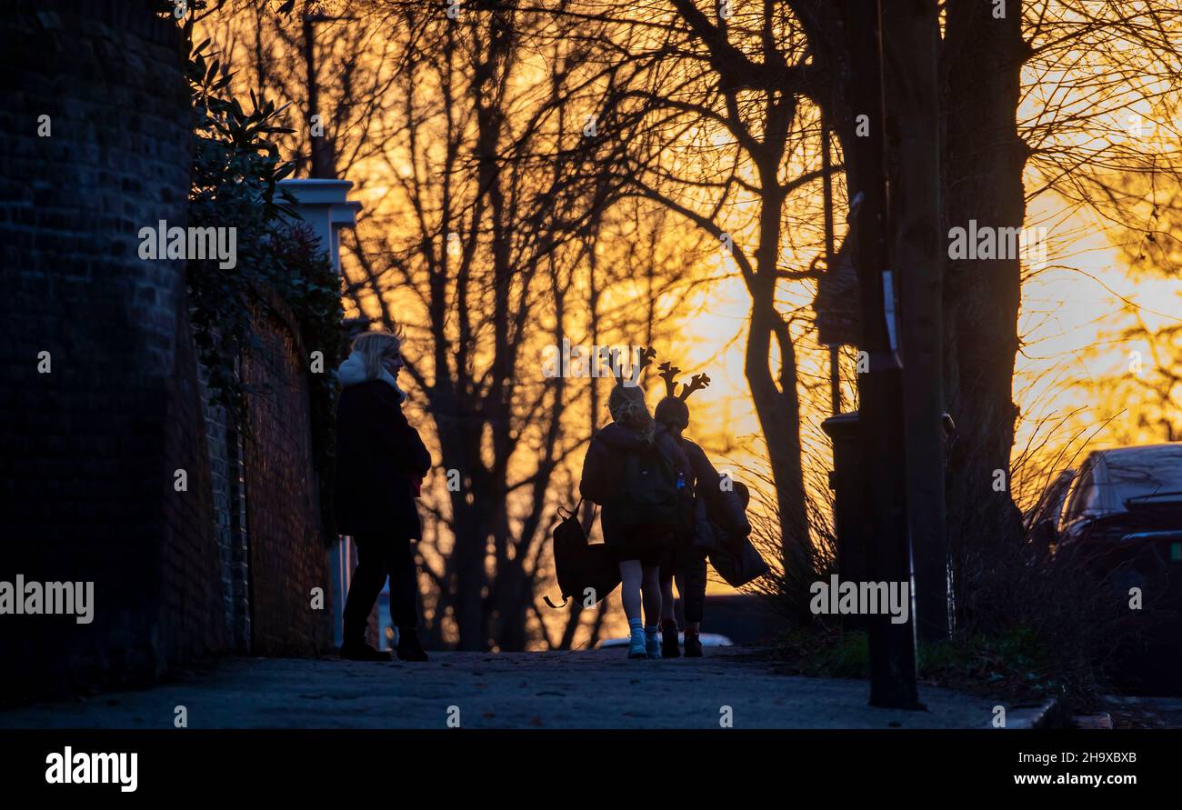 Bild zeigt: Highgate - zwei Schüler in weihnachtlicher Geweih-Kopfbedeckung Cold Evening Walk, während die Londoner über neue Covid-Beschränkungen für Plan B nachdenken Stockfoto