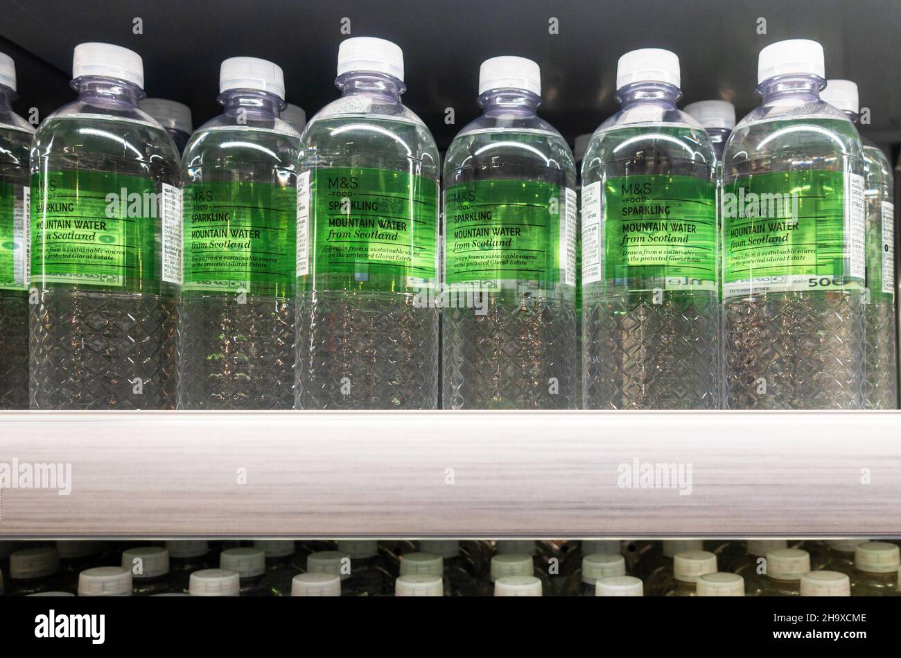 Flaschen mit glitzerndem Bergwasser aus Schottland auf einem Regal in der Marks & Spencer Foodhall Stockfoto