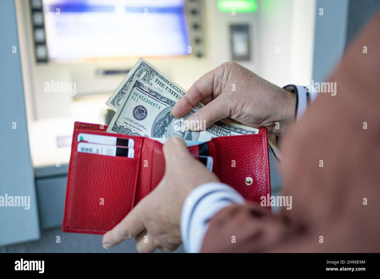 Nicht erkennbare weibliche Hand, die am Geldautomaten Geld von der Kreditkarte abzieht. Moderne Technologie, Bankgeld, Finanzmanagement, Geld sparen, Rückzug Stockfoto