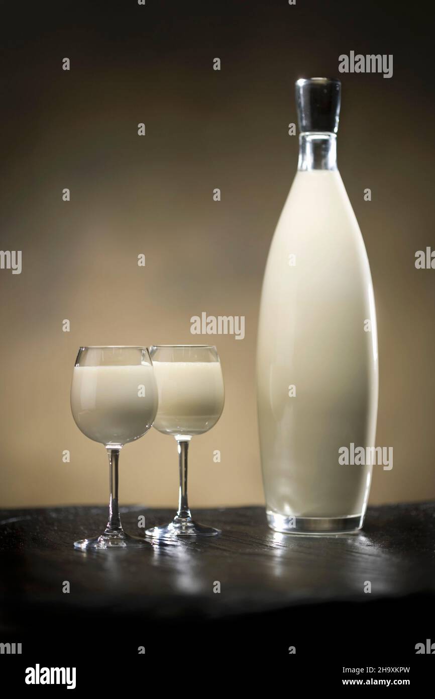 Cocktail aus weißem Zwieback in Flaschen mit zwei gallen auf Schieferoberfläche und goldenem Hintergrund Stockfoto