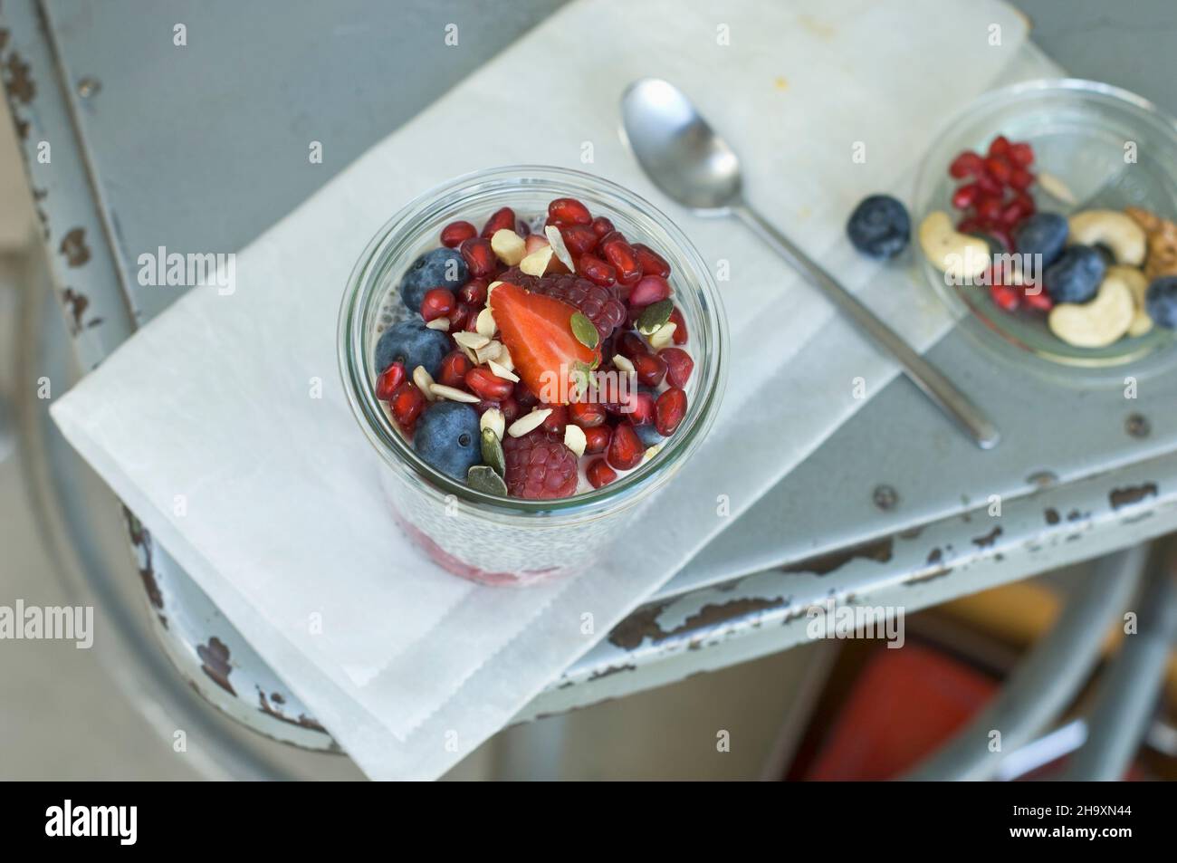 Chia Pudding mit Sommerfrüchten und Nüssen in einem Glas auf einem alten  Stuhl Stockfotografie - Alamy