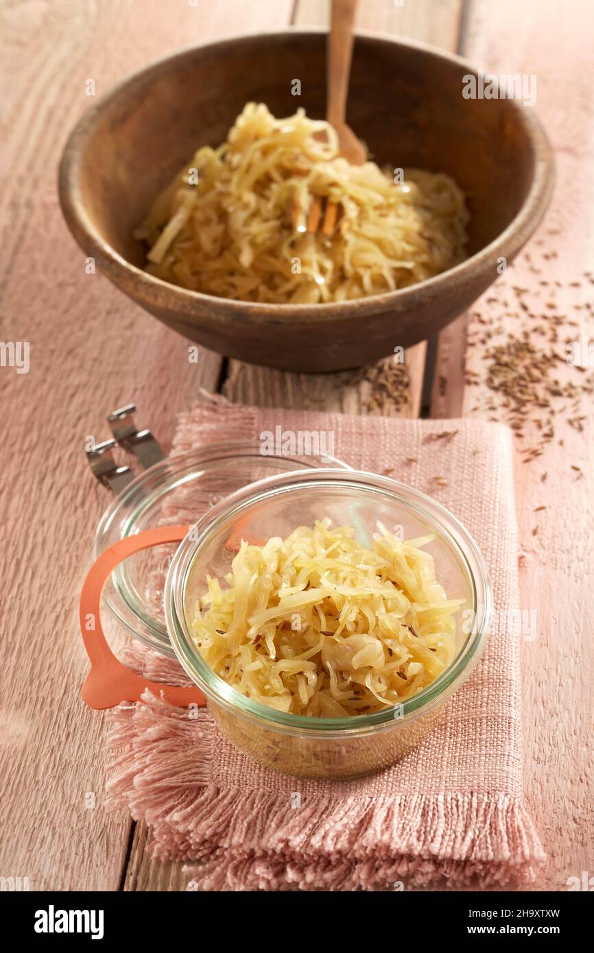 Sauerkraut aus Spitzkohl in einer Holzschüssel und einem Glas Stockfoto