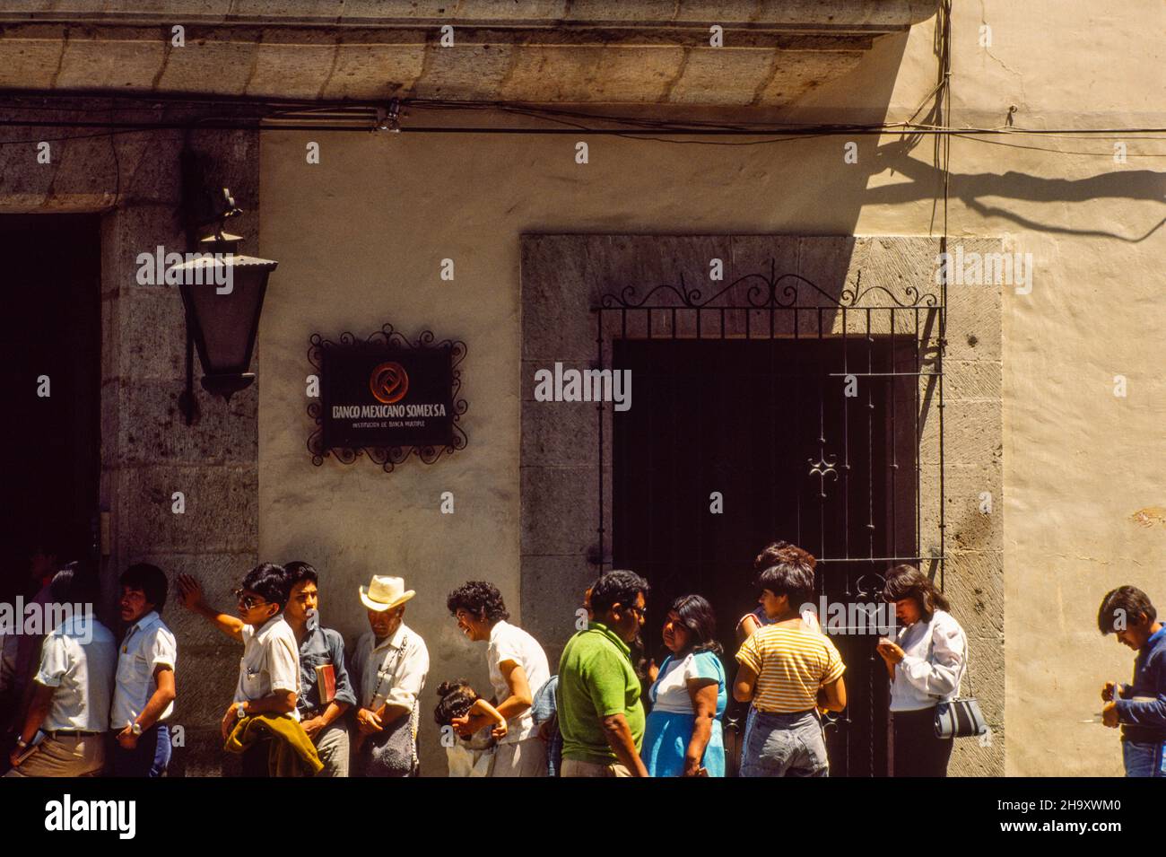 Menschen warten in einer langen Schlange vor einer Bank in Oaxaca, Mexiko Stockfoto