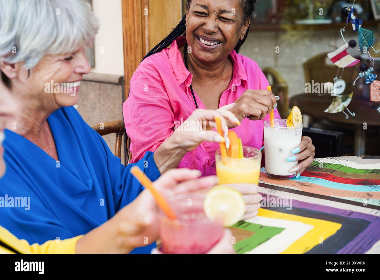 Ältere Freunde aus verschiedenen Rassen, die Spaß haben, im Bar-Restaurant keine alkoholischen Cocktails zu trinken - konzentrieren Sie sich auf afrikanische Frau Stockfoto