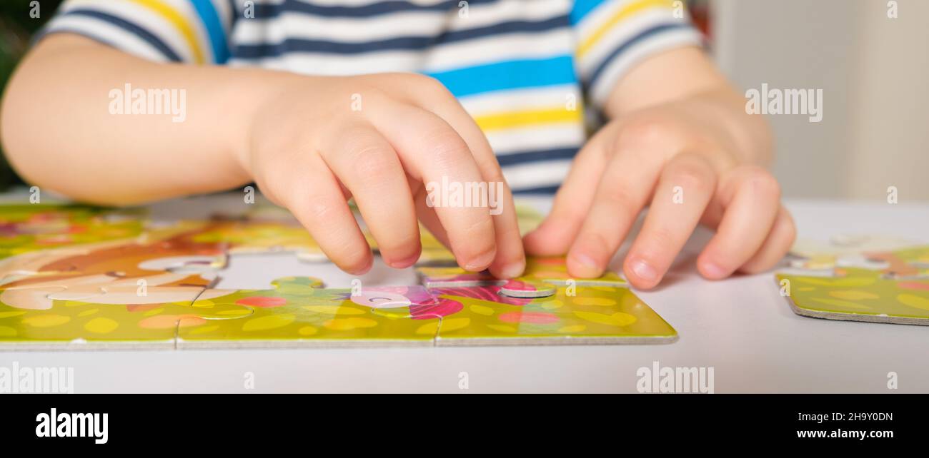 Die Hände des Kindes aus der Nähe stellen ein Bild von Rätseln zusammen Stockfoto