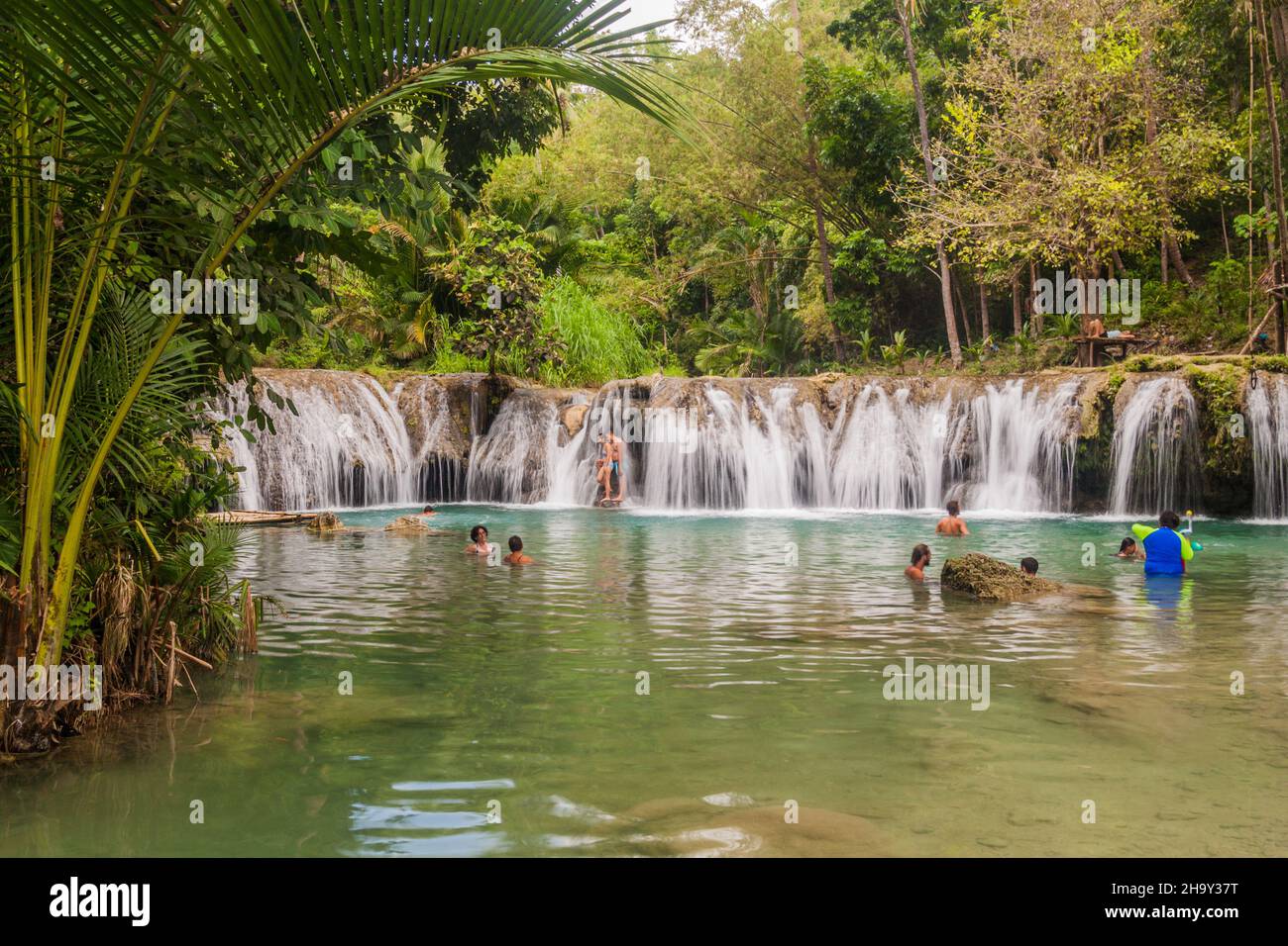 SIQUIJOR, PHILIPPINEN - 9. FEBRUAR 2018: Die Menschen genießen die Cambugahay Falls auf der Insel Siquijor, Philippinen. Stockfoto