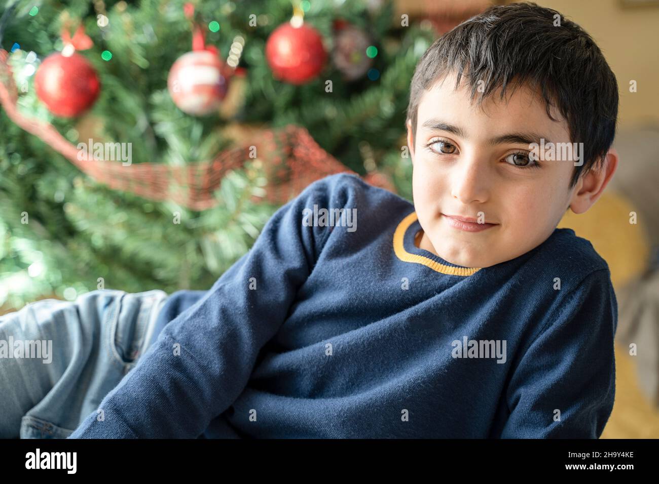 Kleiner kaukasischer Junge entspannte sich zu Hause in Weihnachtsstimmung Stockfoto
