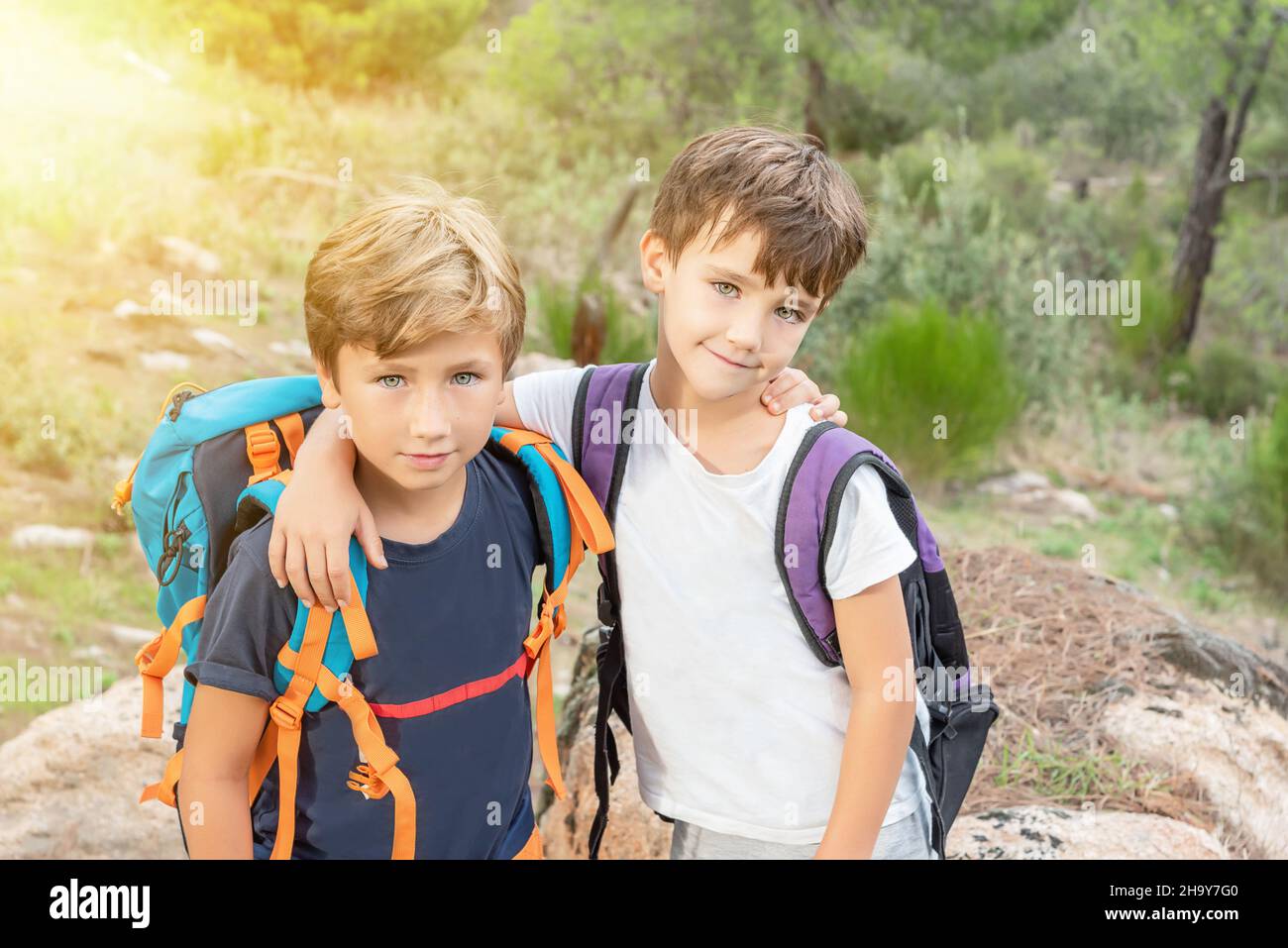 Zwei Wanderkinder mit ihren Rucksäcken im Busch freuen sich, das Ende des Weges zu erreichen. Pfadfinder wandern im Wald Stockfoto