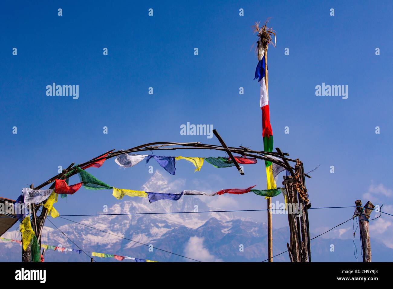 Buddhistische Gebetsfahnen im Himalaya-Vorgebirgsdorf Dhampus, Nepal, mit Machhapuchare hinter sich. Stockfoto