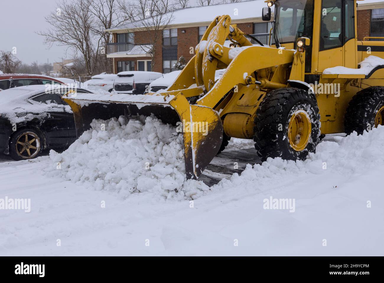 Traktor Schneeräumung Straßenwartung mit starkem Schneefall Stockfoto