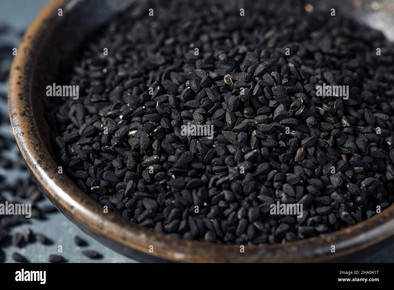 Rohes schwarzes Bio-Charnushka Zwiebelsamen-Gewürz in einer Schüssel Stockfoto