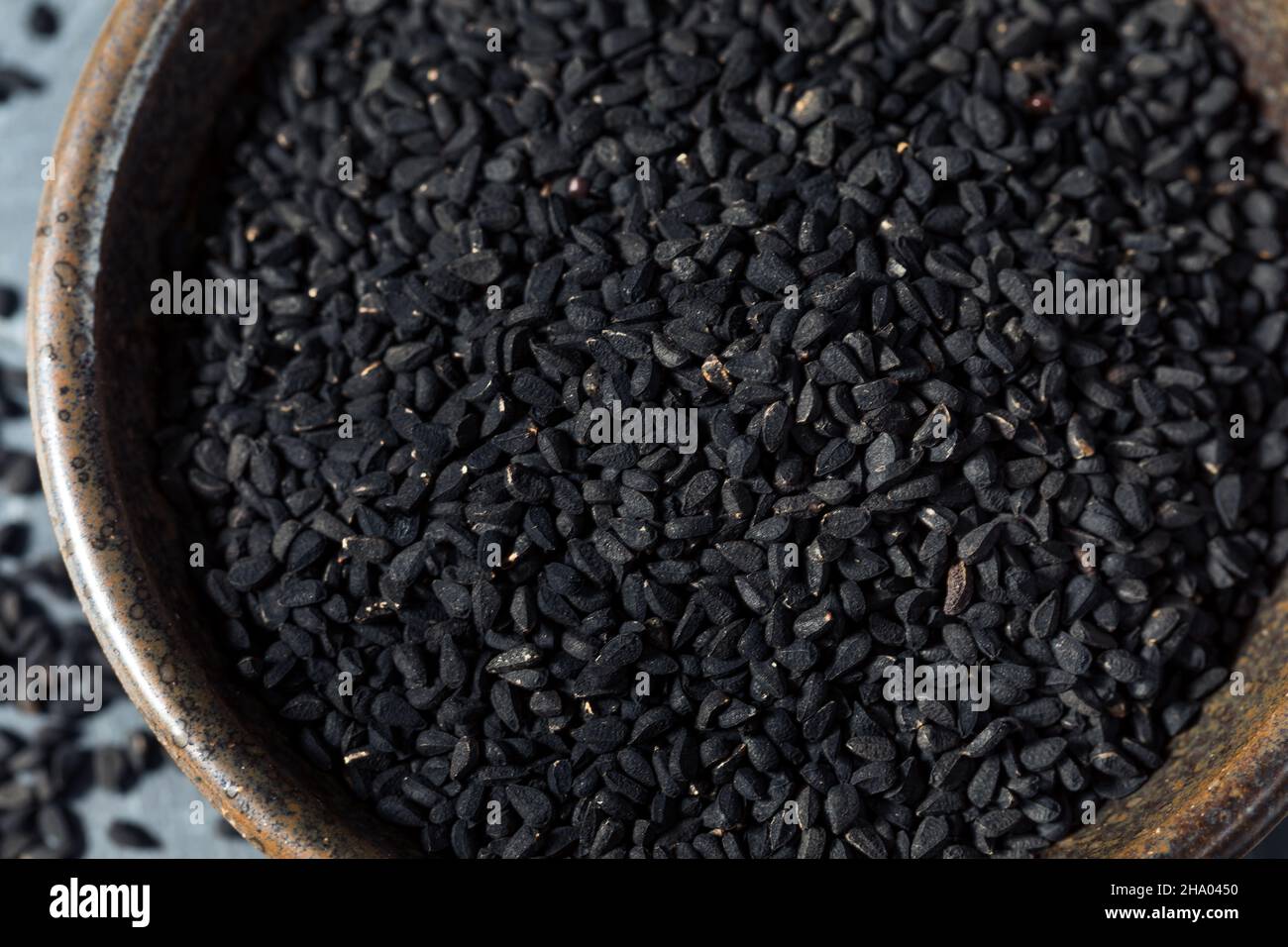 Rohes schwarzes Bio-Charnushka Zwiebelsamen-Gewürz in einer Schüssel Stockfoto