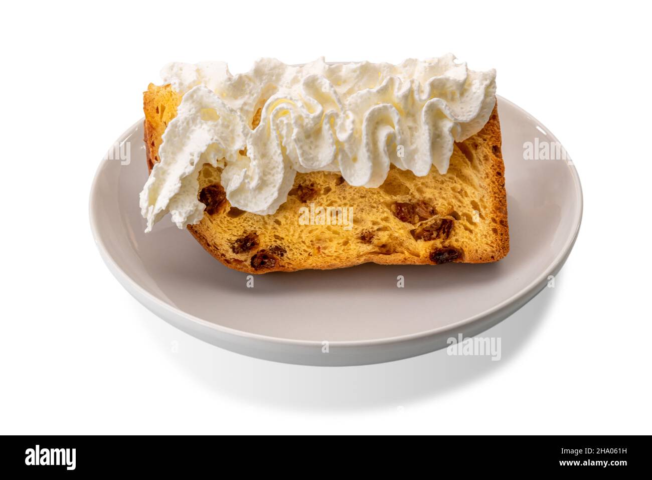 Scheibe Panettonkuchen mit Schlagsahne auf weißem Teller isoliert auf weißem, typisch italienischem Weihnachtsdessert Stockfoto