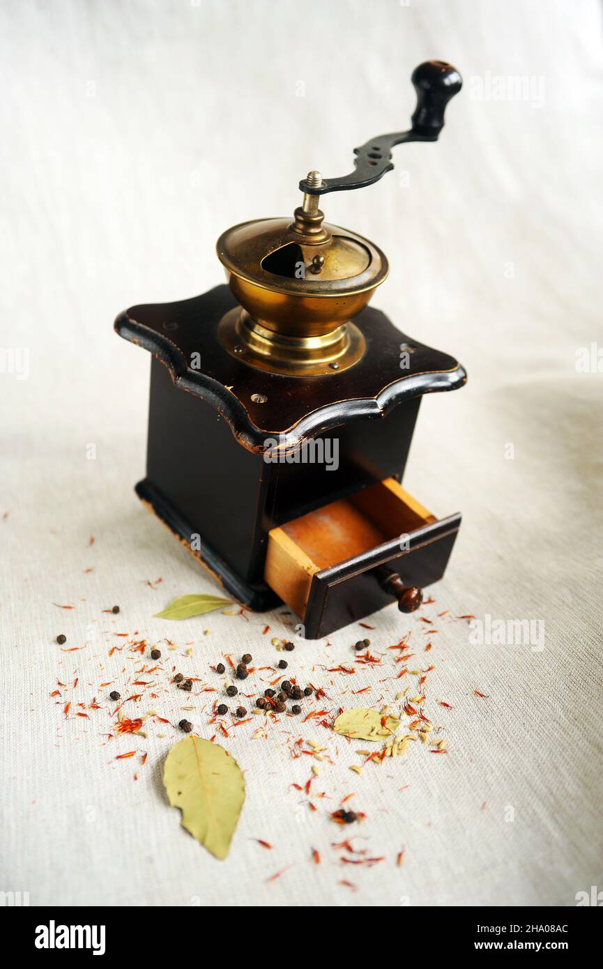 Vintage Messingmühle oder Mühle und einige Gewürze Stockfoto