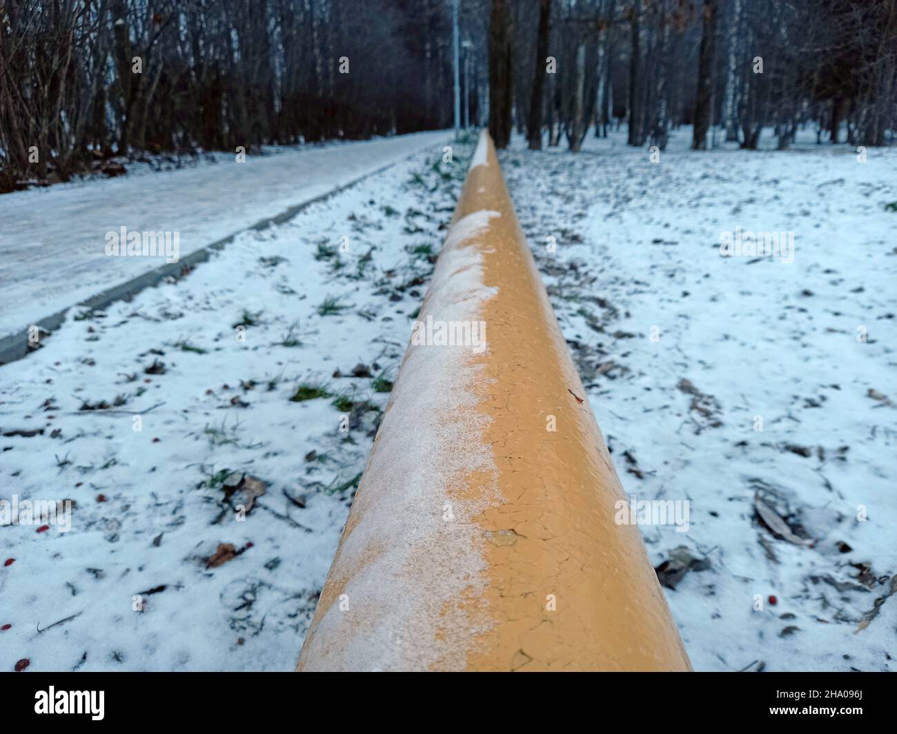 Gelbe Gasleitung im Winter unter freiem Himmel. Gaspipeline auf der Straße. Stockfoto