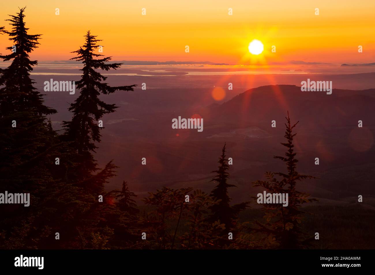 WA19860-00...WASHINGTON - die Sonne geht durch einen rauchigen Himmel über der Straße von Juan de Fuca und den Puget Sound Lowlands unter Stockfoto