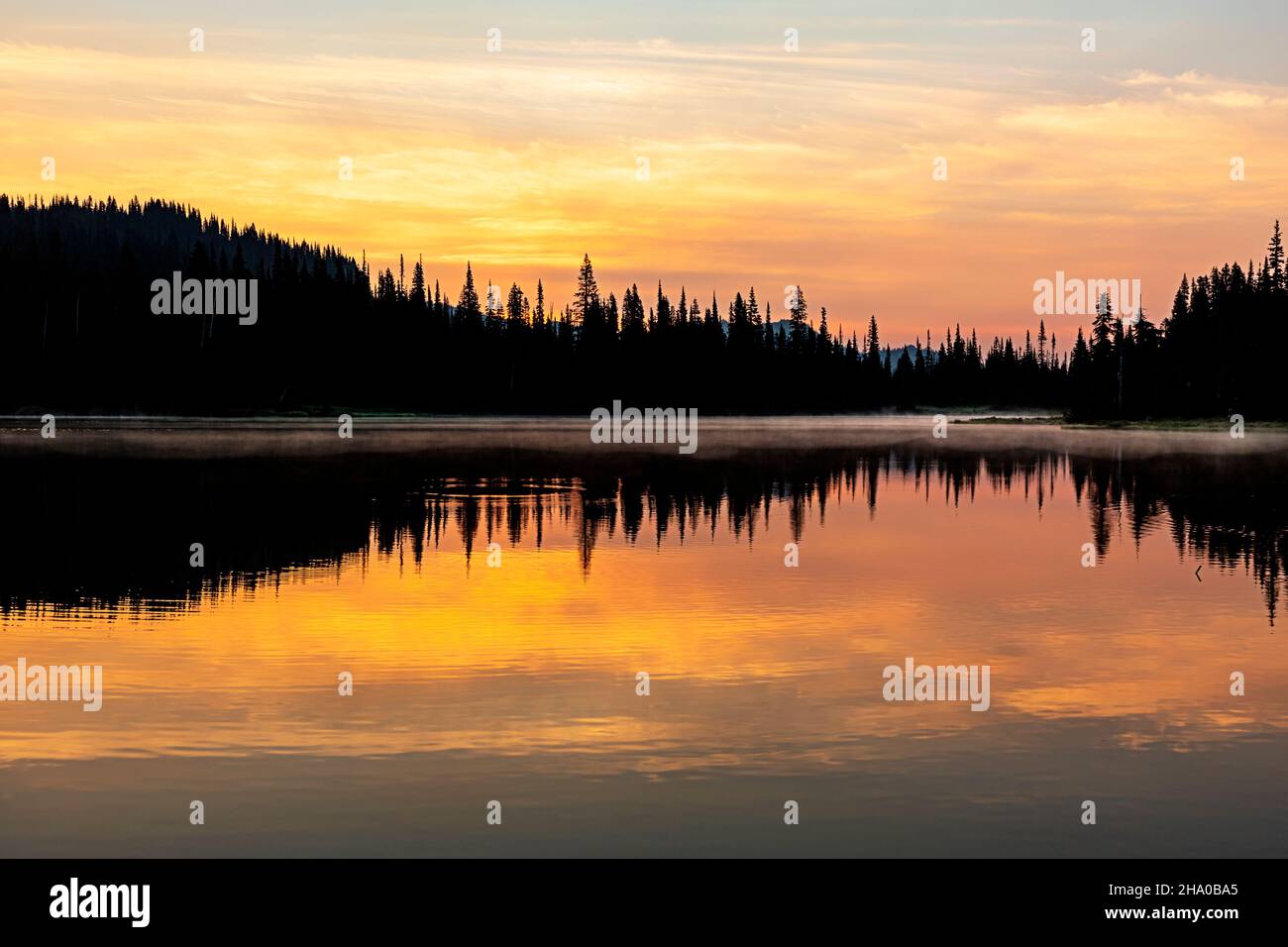 WA19864-00...WASHINGTON - Sonnenaufgang auf einem rauchgefüllten Himmel, der sich in Reflection Lakes im Mount Rainier National Park widerspiegelt. Stockfoto